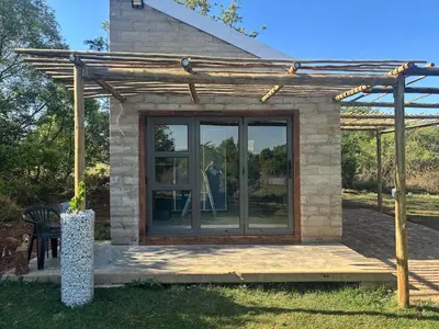 a small house with a woman in the window at Bosch Rest in Pretoria