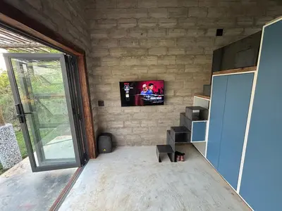 a living room with a tv on a brick wall at Bosch Rest in Pretoria