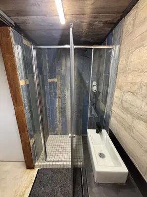 a bathroom with a shower and a toilet and a sink at Bosch Rest in Pretoria