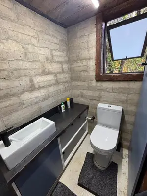 a bathroom with a toilet and a sink and a window at Bosch Rest in Pretoria