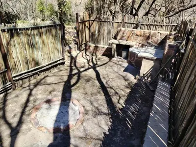 a shadow of a fence and a bench in a yard at A Farm Experience at Shoulder Mountain Products in Vaalwater