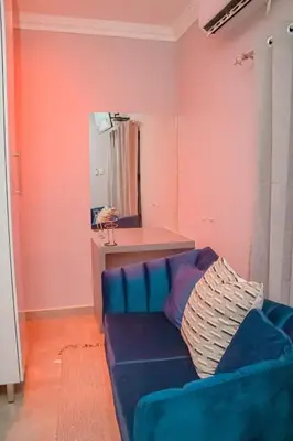 a blue couch in a living room with a mirror at Dzire Guesthouse in Thohoyandou