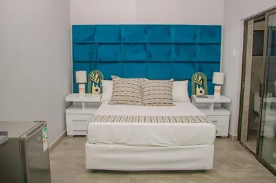 a bedroom with a large bed with a blue headboard at Dzire Guesthouse in Thohoyandou