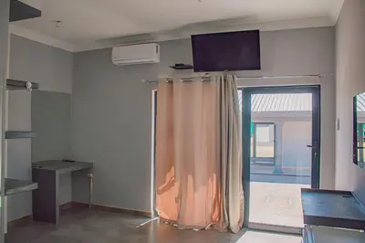 a room with a curtain and a television on the wall at Dzire Guesthouse in Thohoyandou