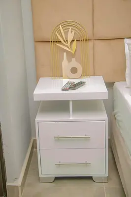 a white night stand next to a bed at Dzire Guesthouse in Thohoyandou