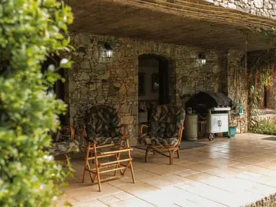 a patio with chairs and a stove in a stone building at Magoebaskloof Mountain Estate in Tzaneen