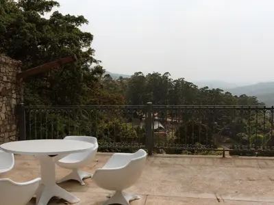 a white table and chairs on a balcony with a view at Magoebaskloof Mountain Estate in Tzaneen