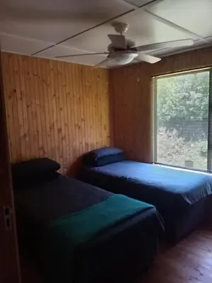 a bedroom with two beds and a ceiling fan at Barberton Troop Cabin in Barberton