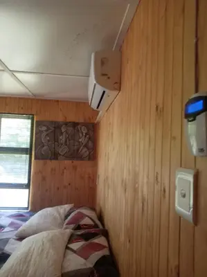 a bedroom with a bed in a wooden wall at Barberton Troop Cabin in Barberton