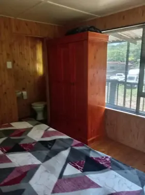 an empty room with a bed and a window at Barberton Troop Cabin in Barberton