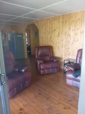 a living room with two leather chairs and a table at Barberton Troop Cabin in Barberton