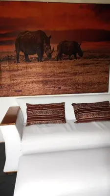 a painting of two rhinos walking in a field at River Rock Safari Hebron, Kgabakatsane