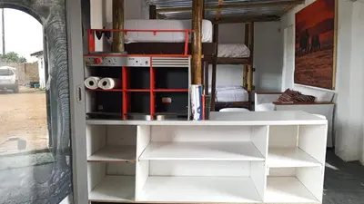 a room with white shelves and a bed at River Rock Safari Hebron, Kgabakatsane