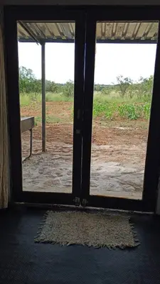 an open door with a view of a field at River Rock Safari Hebron, Kgabakatsane
