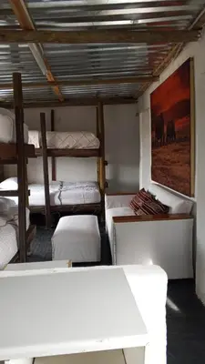 a room with several beds and a painting on the wall at River Rock Safari Hebron, Kgabakatsane