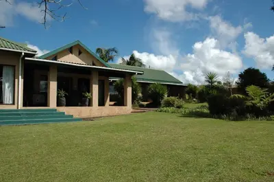 a house with a green roof and a yard at Elephant's Nest in Graskop