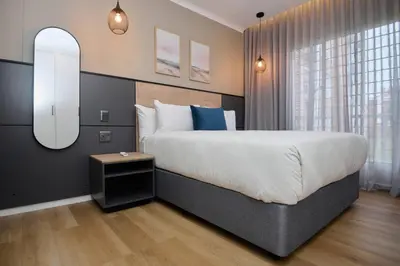 a bedroom with a large bed and a mirror at Unit 109 at Glen Park in Pretoria