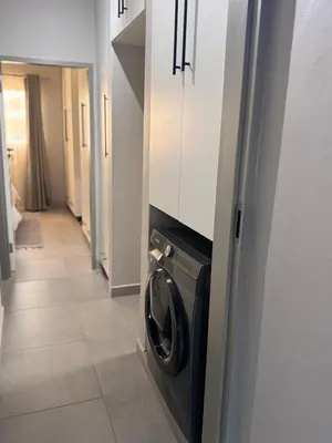 a kitchen with a washer and dryer in a hallway at Menlyn Private Escape in Pretoria