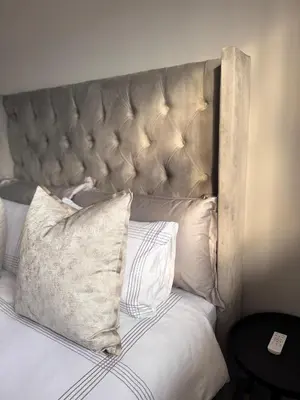 a bed with a large headboard with pillows on it at Menlyn Private Escape in Pretoria