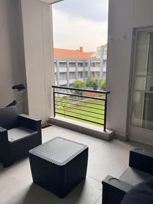 a room with chairs and a balcony with a view at Menlyn Private Escape in Pretoria