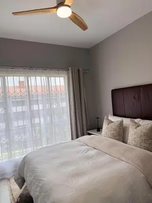 a bedroom with a bed and a ceiling fan at Menlyn Private Escape in Pretoria