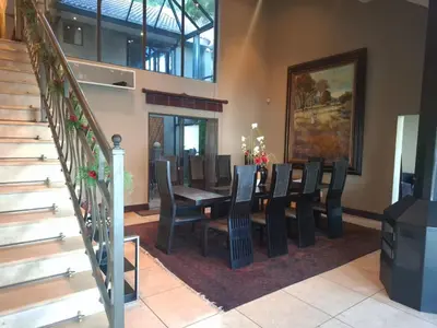 a dining room with a table and chairs at MiCasa in Hartbeespoort