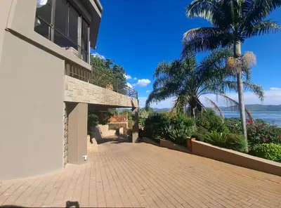 a house with a brick walkway and palm trees at MiCasa in Hartbeespoort