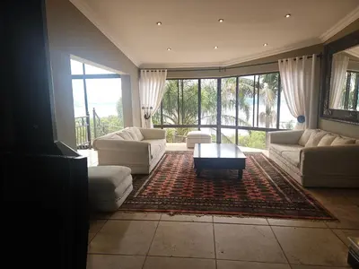 a living room with white furniture and a large window at MiCasa in Hartbeespoort