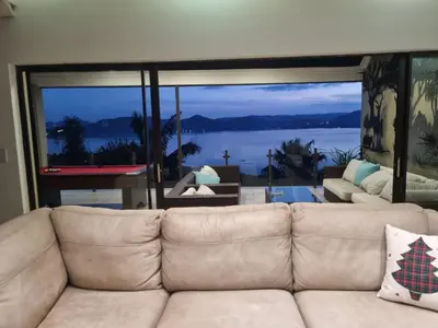 a living room with a couch and a large window at MiCasa in Hartbeespoort