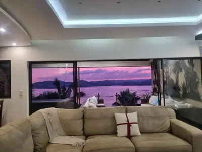 a living room with a couch and a large window at MiCasa in Hartbeespoort