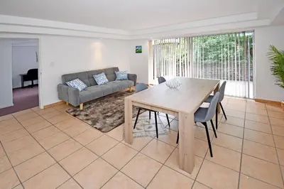 a living room with a wooden table and a couch at Sandton Elite Stay in Sandton