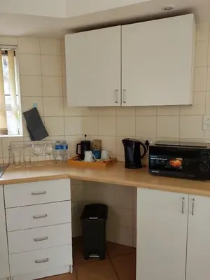 a kitchen with white cabinets and a black microwave at Sandton Elite Stay in Sandton