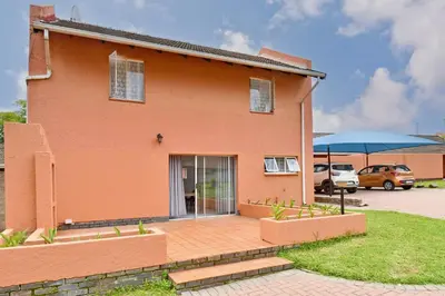 a orange house with a patio in front of it at Sandton Elite Stay in Sandton