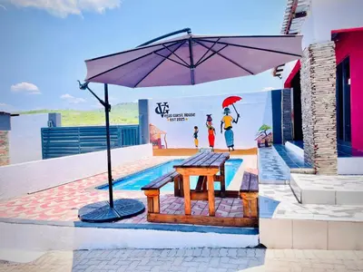 a picnic table with an umbrella in front of a mural at Vegas guest house in Dwarsloop