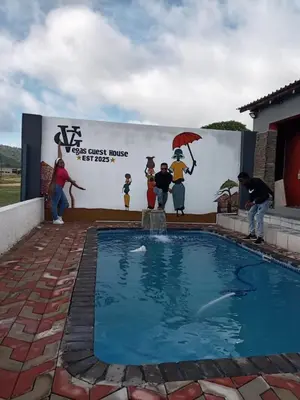 a group of people standing around a pool with a shark in the water at Vegas guest house in Dwarsloop