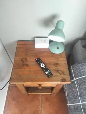 a table with two remote controls and a lamp on it at Witbank Dam Self Check In in Witbank