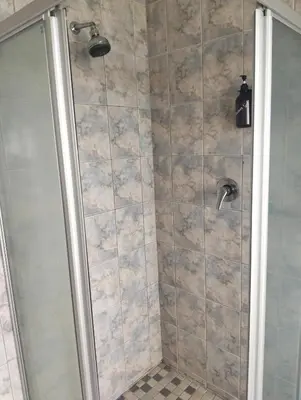 a bathroom with a shower with a glass door at Witbank Dam Self Check In in Witbank