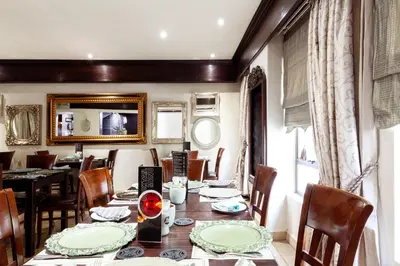 a dining room with a table and chairs at InnJoy Boutique Hotel in Centurion