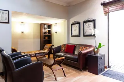 a living room with a leather couch and chairs at InnJoy Boutique Hotel in Centurion