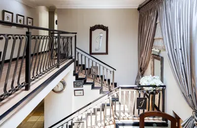 a staircase in a home with white walls and wooden railings at InnJoy Boutique Hotel in Centurion