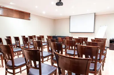 a lecture room with chairs and a white screen at InnJoy Boutique Hotel in Centurion