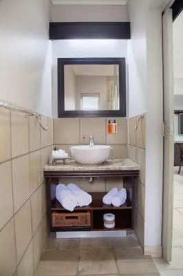 a bathroom with a sink and a mirror at InnJoy Boutique Hotel in Centurion