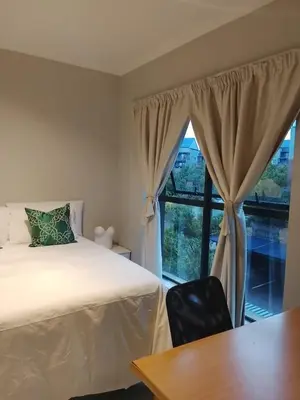 a bedroom with a bed and a large window at Cosy 1 bedroom Apartment in Midrand