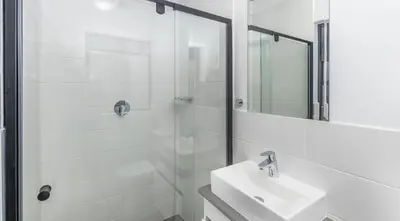 a white bathroom with a sink and a shower at Cosy 1 bedroom Apartment in Midrand