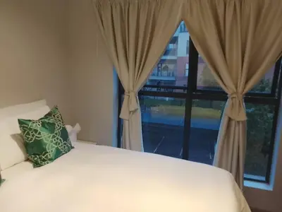 a bedroom with a bed and a large window at Cosy 1 bedroom Apartment in Midrand