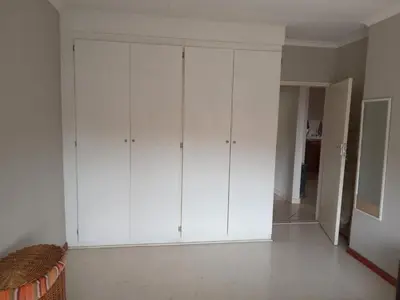 a white closet with white cabinets in a room at Nested at L&M in Centurion