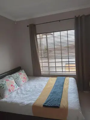 a bedroom with a bed with a large window at Nested at L&M in Centurion
