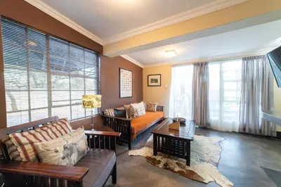 a living room with a couch and a table at Khayamanzi Guesthouse in Hartbeespoort