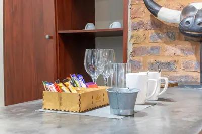 a table with a box and cups on a table at Khayamanzi Guesthouse in Hartbeespoort