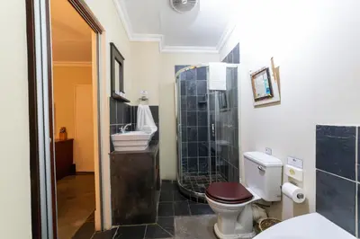 a bathroom with a toilet and a sink at Khayamanzi Guesthouse in Hartbeespoort